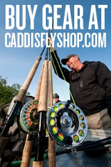 A man holding several rods and reels